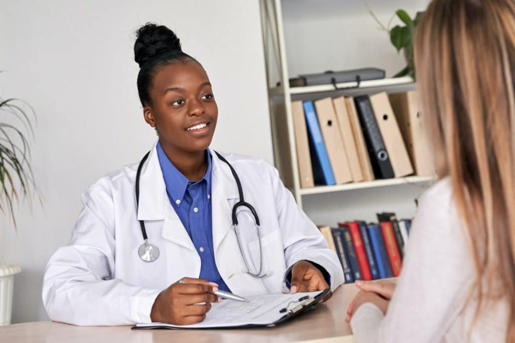 A doctor physician consulting caucasian woman patient at medical visit.